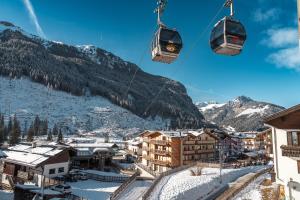 卡纳泽伊B&B Cèsa Planber Mountain View SKI-IN SKI-OUT的一座覆盖着白雪皑皑的山脉的小镇上的滑雪缆车