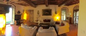 a living room with white chairs and a couch at Poggio Rozzi in Tavarnelle in Val di Pesa