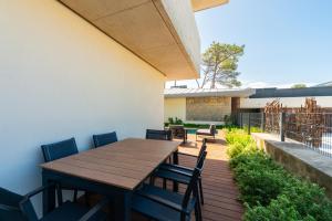 ein Holztisch und Stühle auf einer Terrasse in der Unterkunft Cascais Sandwoods Luxury Villa in Cascais