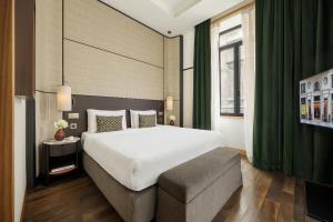 a bedroom with a large white bed and a couch at Park Hyatt Milano in Milan