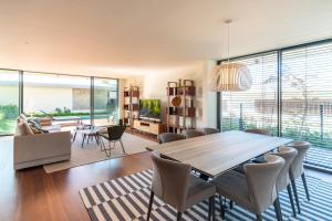 ein Wohnzimmer mit einem Holztisch und Stühlen in der Unterkunft Cascais Sandwoods Luxury Villa in Cascais