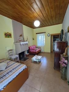 a bedroom with a bed and a living room with a fireplace at Ktimata Evdoxia in Platanoússa