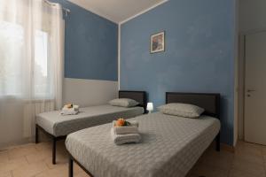 Dos camas en una habitación con paredes azules. en GajoSanti apartments, en Vicenza