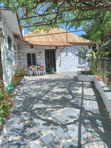 a patio of a house with a table and chairs at Ktimata Evdoxia in Platanoússa