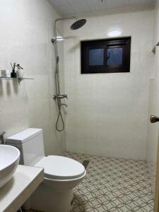 a bathroom with a toilet and a sink and a shower at Sofia's Unit - 2 Bedroom with complimentary breakfast in Baguio +12 photos