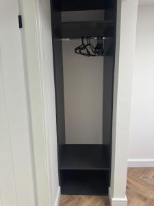 a room with a closet with a black door at Outer apartment - park view in Llandudno