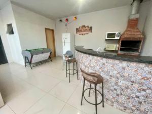 a kitchen with a bar and a pool table at Casa 19 pessoas, piscina e jacuzzi in Nova Mutum