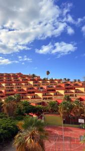 un grande condominio con palme e un campo da tennis di Costa Adeje Sunset Ocean View with Terrace C By-Tenerife365 ad Adeje