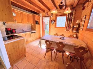 a kitchen with a table and chairs in a cabin at Chalet De Julie - Bel appartement traditionnel 4 pièces sur 2 niveau pour 6 personnes MAE-3734 in Saint-Martin-de-Belleville +5 photos