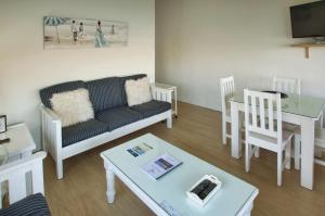 een woonkamer met een bank en een tafel bij Sea Cottage, Langebaan, 4-sleeper in Langebaan