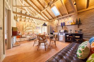 ein Wohnzimmer und eine Küche mit einem Tisch und Stühlen in der Unterkunft Melro Cottage House, Douro Valley in Aldeia de Baixo