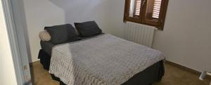 a bedroom with a bed with black pillows on it at Maison d'exception au Cap Corse in Luri +3 photos