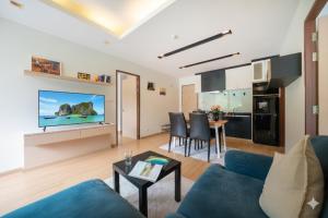 ein Wohnzimmer mit einem blauen Sofa und einem Tisch in der Unterkunft Hillside 2BR Apartment with Pool & Gym 5 Min to Kamala Beach 48RK in Kamala Beach