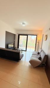 a living room with two couches and a large window at Aphrodite Gardens Modern Apartment in Paphos +9 photos