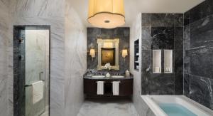 a bathroom with a sink and a tub and a mirror at Kempinski Al Othman Hotel Al Khobar in Al Khobar +128 photos