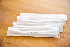 three white tooth brushes sitting on a wooden table at ルーベンス博多 in Fukuoka +4 photos