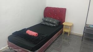 a small bed with two pillows on top of it at Anatolia Cottage in Wakaf Baharu