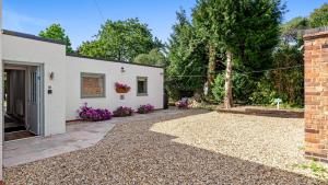a house with a gravel driveway next to a building at Rose Cottage, Bredons Norton in Bredon