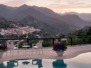 a pool with chairs and a table and a view of mountains at Casa Rural Caserío Las Viñas in Guájar Fondón