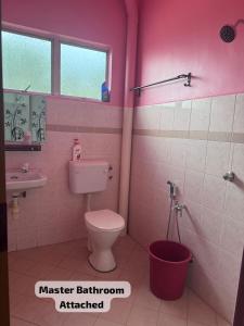 a pink bathroom with a toilet and a sink at SP Mawar Guest House in Kampong Ulu Melaka Pindah +24 photos