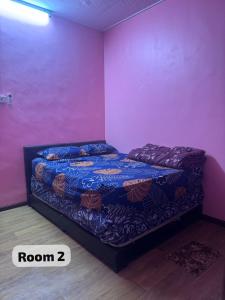 a bedroom with a bed in a pink room at SP Mawar Guest House in Kampong Ulu Melaka Pindah
