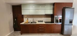 a kitchen with wooden cabinets and a stainless steel refrigerator at Cozy&bright apartment Kotor in Kotor +6 photos