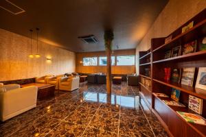 a lobby with a waiting room with couches and tables at Umine Annex in Beppu