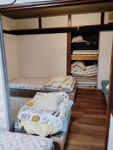 a room with three bunk beds in a room at Guesthouse MARU 1日1組 犬と泊まれる貸切の民家宿 丸 ファミリー グループ向け民家の宿 Vintage House, Parking, Free Wifi, Smoke free in Ishinomaki