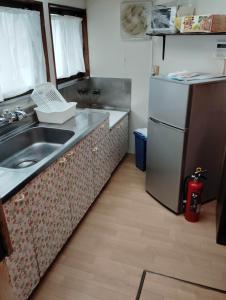 a kitchen with a sink and a refrigerator at Guesthouse MARU 1日1組 犬と泊まれる貸切の民家宿 丸 ファミリー グループ向け民家の宿 Vintage House, Parking, Free Wifi, Smoke free in Ishinomaki