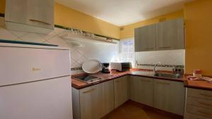 Una cocina con un refrigerador blanco y un fregadero. en Gran Rey n1, en Calera 11 fotos más