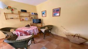 Una habitación con una mesa y sillas y un televisor. en Gran Rey n1, en Calera