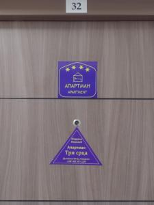 a purple sign on a wooden door with a pyramid at Tri srca in Kladovo