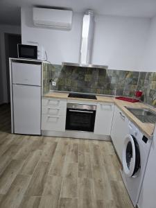 a kitchen with a stove and a washer and dryer at Apartamentos Vacacionales Malba Primero A in Punta Umbría