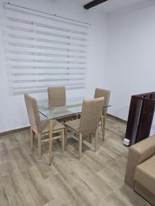a dining room with a glass table and chairs at Apartamentos vacacionales malba in Punta Umbría