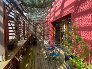 a patio with a table and chairs and a pink wall at Le Canopée in Villefranche-sur-Saône