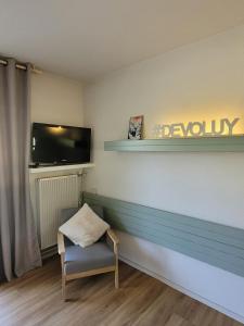 a living room with a chair and a television at appartement superdevoluy in Le Dévoluy
