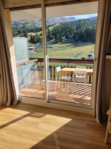 a balcony with a table and chairs on a deck at appartement superdevoluy in Le Dévoluy