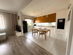 a large kitchen with a table and chairs in it at Apartament Przestronny in Puck