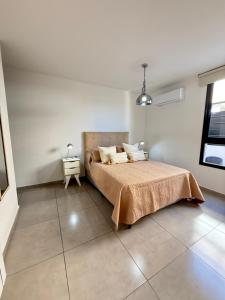 a bedroom with a bed in a white room at Departamento premium con amplio patio en pleno centro de Carlos Paz in Villa Carlos Paz +47 photos