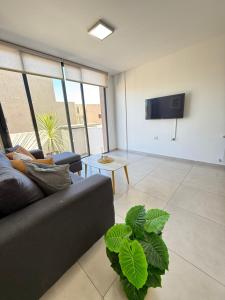 a living room with a couch and a flat screen tv at Departamento premium con amplio patio en pleno centro de Carlos Paz in Villa Carlos Paz
