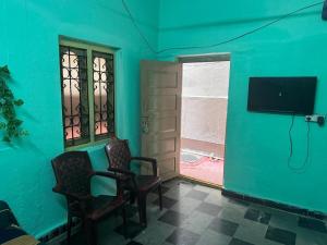 a room with two chairs and a flat screen tv at Cozy and classy in Secunderabad