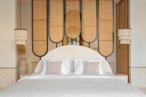 a bedroom with a large white bed with pillows at Ocean Verve Villa 1 in Uluwatu +12 photos