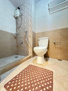 a bathroom with a toilet and a shower and a rug at Mplace residence tower A in Manila