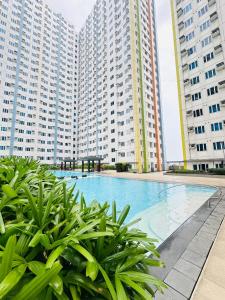 a swimming pool in the middle of two tall buildings at Mplace residence tower A in Manila +12 photos