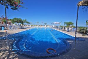 una grande piscina con acqua blu in un resort di Santorini Camping & Hostel a Firà