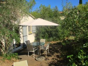 a table and chairs and an umbrella on a deck at Le mazet d'Uzès in Uzès