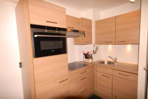 a small kitchen with wooden cabinets and a sink at Résidence Marmottes - 2 Pièces pour 8 Personnes MAE-6013 in Gourette +3 photos