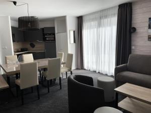 a living room with a table and chairs and a kitchen at Résidence Le Portillo - Piscine - 2 Pièces pour 8 Personnes MAE-6123 in Gourette