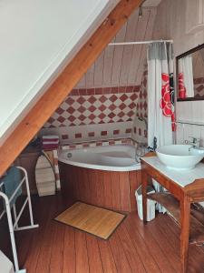 a bathroom with a bath tub and a sink at Le Jardin De Glenmor Belle-île in Séné