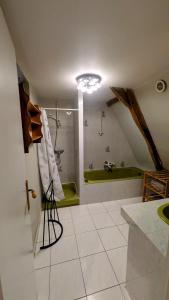 a bathroom with a green tub and a sink at House - comfortable - spacious - 15' from Lille in Leers +11 photos